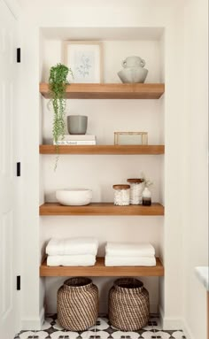 a white bathroom with open shelving and towels