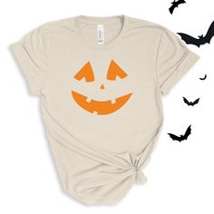 a t - shirt with an image of a pumpkin on it and bats flying around