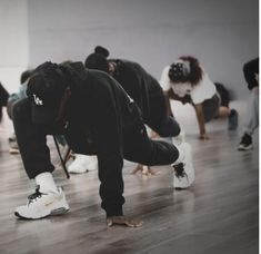 a group of people standing on top of a hard wood floor next to each other