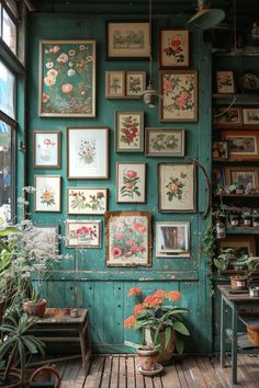 a room filled with lots of framed pictures on the wall next to potted plants