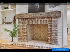 a living room with a brick fireplace in the center and white painted walls behind it