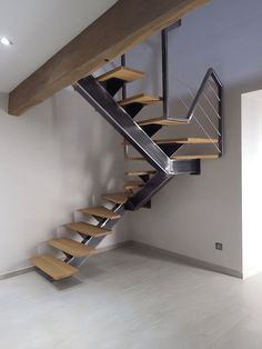 a wooden and metal staircase in an empty room