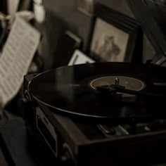 an old record player sitting on top of a table next to music sheets and pictures