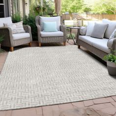 an outdoor area with couches, chairs and a rug