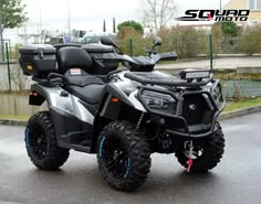 a black and silver four - wheeler parked on the street