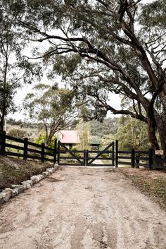 a dirt road leading to a fenced in area