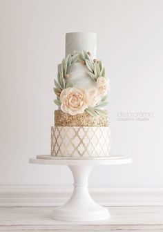 a white and gold wedding cake with flowers on the top is featured in an instagram