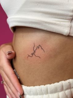 a woman's stomach with a small tattoo on it