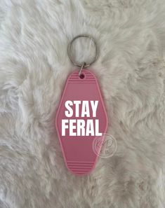 a pink keychain with the words stay federal on it sitting on a furry surface