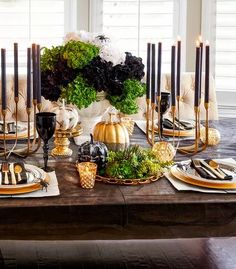 a dining room table set with candles, plates and place settings for an elegant thanksgiving dinner