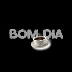 a cup of coffee sitting on top of a saucer next to the word bombdia