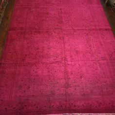 an old pink rug is laying on the floor