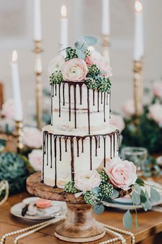 a wedding cake with chocolate drizzles and pink flowers on top is featured in this instagram