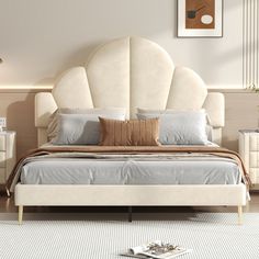 a large white bed sitting in a bedroom on top of a hard wood floor