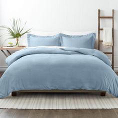 a bed with blue sheets and pillows in a room