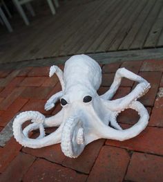 an octopus sculpture is laying on the ground