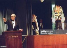 a man in a tuxedo standing at a podium