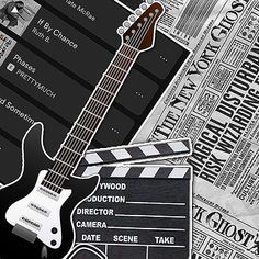 an electric guitar sitting next to a movie clapper on top of a newspaper page