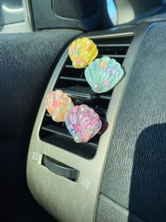 the car air vent is filled with colorful plastic hearts