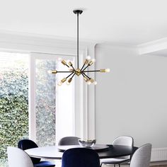 a dining room table with chairs and a chandelier in the middle of it