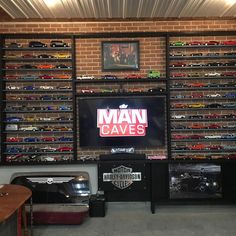 there is a man cave with many cars on the wall and a television in the corner