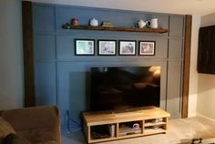 a flat screen tv sitting on top of a wooden entertainment center in a living room