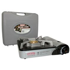 a portable stove with the lid open next to it's case on a white background