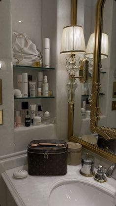 a bathroom sink with a mirror above it and a suitcase on the counter in front of it