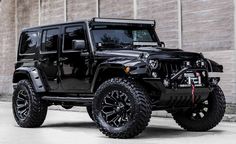 a black jeep parked in front of a brick building