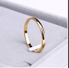 a close up of a gold ring on a white box with the word love written in it