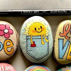 three painted rocks with different designs on them and the words love are in front of each other