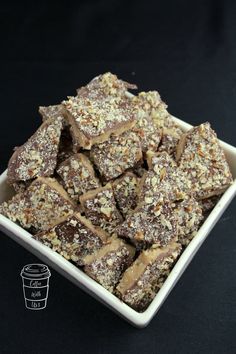 a white bowl filled with chocolate and nuts