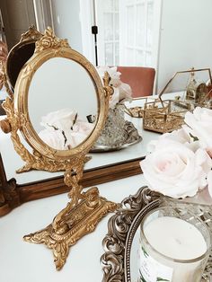 a mirror sitting on top of a table next to a vase with flowers in it