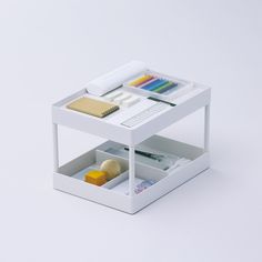 a white desk with two drawers on each side and some pens and pencils in them