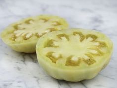 two pieces of green tomato sitting on top of a marble counter