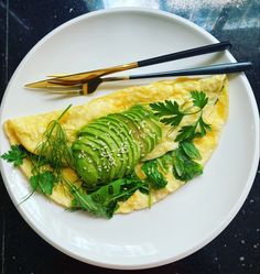 an omelet with cucumber and herbs on a plate