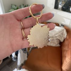 a hand holding a gold colored key chain