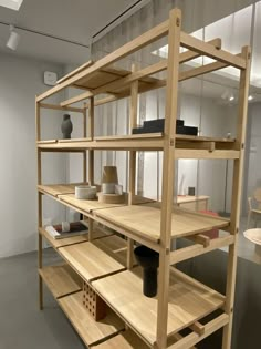 a wooden shelf filled with vases and other items