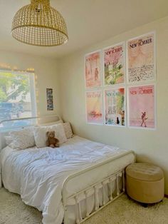 a bedroom with posters on the wall and a bed in front of a large window