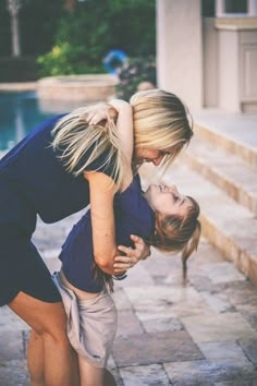 two women hugging each other in front of a pool