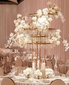 an elegant wedding reception setup with tall centerpieces and white flowers on the tables