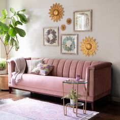 a living room with pink couches and sunflowers on the wall above them