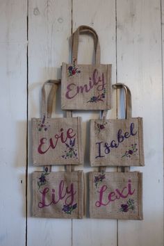 four burlap bags with embroidered words on them