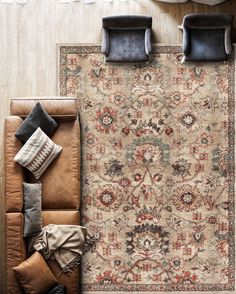 an overhead view of a living room area with couches, rugs and pillows