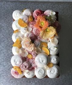 there are many different types of pastries on the counter top, including oranges and white frosting