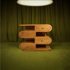 a wooden shelf sitting on top of a green carpeted floor next to a lamp