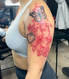 a woman with a butterfly and flower tattoo on her arm