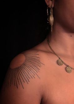 a woman's chest with tattoos on it and two discs hanging from the neck