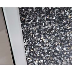 a close up view of some diamonds on the wall in front of a mirror door