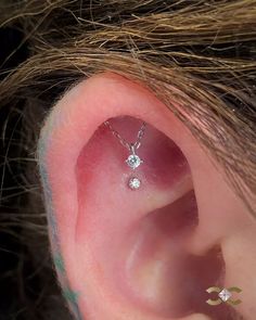 an ear piercing with two small diamonds on it